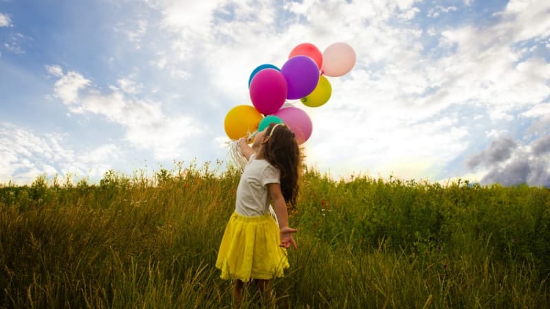 little girl balloons outside